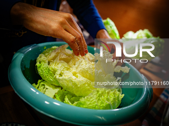 A man salts each loaf of napa cabbage to make Kimchi on November 10, 2024. (