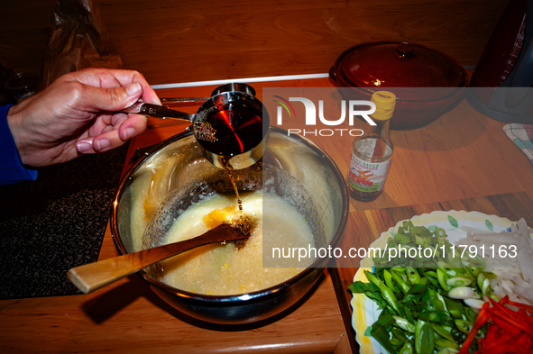 A person adds fish sauce to the paste to make fermented South Korean food, Kimchi, on November 10, 2024. 