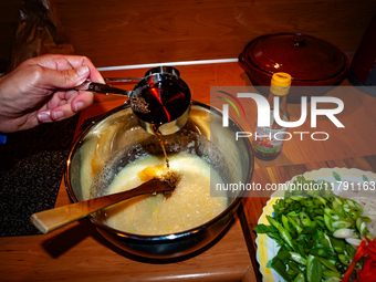 A person adds fish sauce to the paste to make fermented South Korean food, Kimchi, on November 10, 2024. (