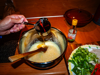 A person adds fish sauce to the paste to make fermented South Korean food, Kimchi, on November 10, 2024. (