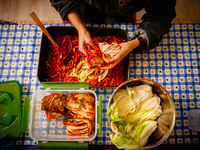 A person soaks the napa cabbage in the kimchi paste during the preparation of fermented Korean food, Kimchi, on November 10, 2024. (