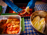 A person soaks the napa cabbage in the kimchi paste during the preparation of fermented Korean food, Kimchi, on November 10, 2024. (