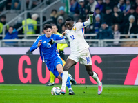 Alessandro Bastoni of Italy and Randal Kolo Muani of France compete for the ball during the UEFA Nations League 2024/25 League A Group 2 mat...