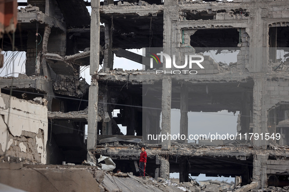 A Palestinian boy walks next to the rubble of a house destroyed in previous airstrikes during the Israeli military offensive, amid the ongoi...