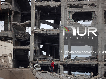 A Palestinian boy walks next to the rubble of a house destroyed in previous airstrikes during the Israeli military offensive, amid the ongoi...