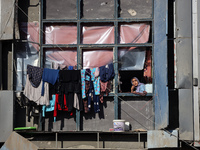 A Palestinian woman looks out from a building destroyed in previous airstrikes during the Israeli military offensive, amid the ongoing confl...