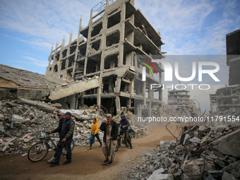 Palestinians walk next to the rubble of a house destroyed in previous airstrikes during the Israeli military offensive, amid the ongoing con...