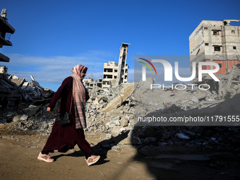 A Palestinian woman walks next to the rubble of a house destroyed in previous airstrikes during the Israeli military offensive, amid the ong...