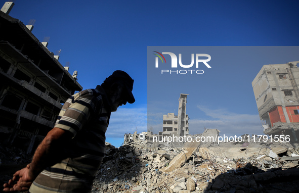 A Palestinian man walks next to the rubble of a house destroyed in previous airstrikes during the Israeli military offensive, amid the ongoi...