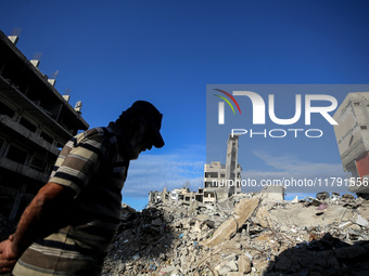 A Palestinian man walks next to the rubble of a house destroyed in previous airstrikes during the Israeli military offensive, amid the ongoi...