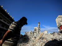 A Palestinian man walks next to the rubble of a house destroyed in previous airstrikes during the Israeli military offensive, amid the ongoi...