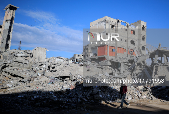 A Palestinian man walks next to the rubble of a house destroyed in previous airstrikes during the Israeli military offensive, amid the ongoi...