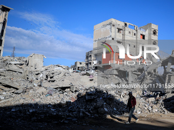 A Palestinian man walks next to the rubble of a house destroyed in previous airstrikes during the Israeli military offensive, amid the ongoi...