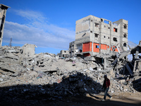 A Palestinian man walks next to the rubble of a house destroyed in previous airstrikes during the Israeli military offensive, amid the ongoi...