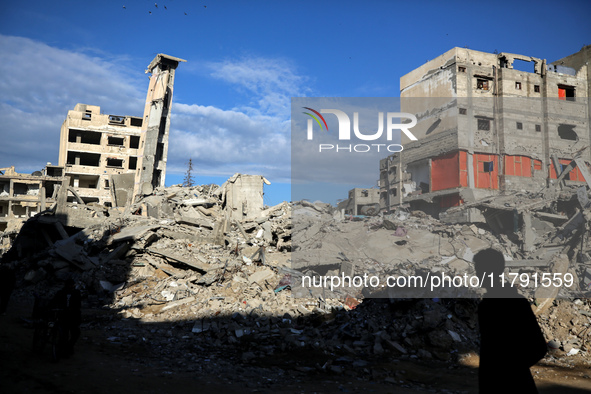 A Palestinian boy walks next to the rubble of a house destroyed in previous airstrikes during the Israeli military offensive, amid the ongoi...