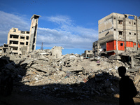 A Palestinian boy walks next to the rubble of a house destroyed in previous airstrikes during the Israeli military offensive, amid the ongoi...