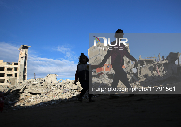 Palestinian children walk next to the rubble of a house destroyed in previous airstrikes during the Israeli military offensive, amid the ong...