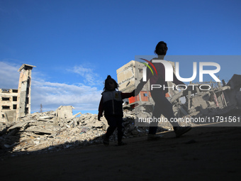 Palestinian children walk next to the rubble of a house destroyed in previous airstrikes during the Israeli military offensive, amid the ong...