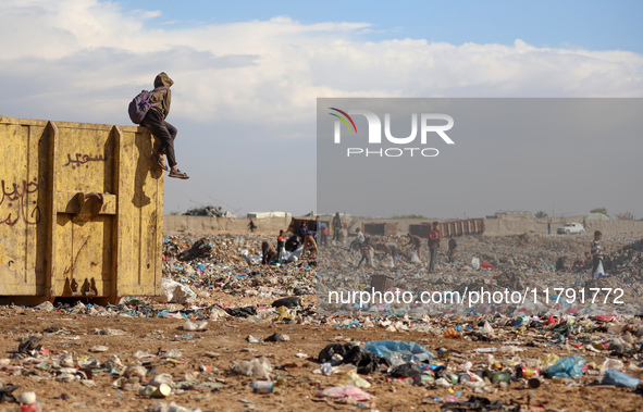 A Palestinian searches through a pile of garbage in Khan Yunis, Gaza Strip, on November 19, 2024, amid the ongoing war between Israel and th...