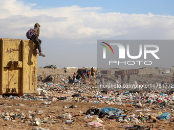 A Palestinian searches through a pile of garbage in Khan Yunis, Gaza Strip, on November 19, 2024, amid the ongoing war between Israel and th...