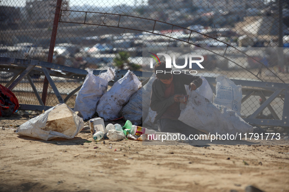 A displaced Palestinian boy searches through a pile of garbage in Khan Yunis, Gaza Strip, on November 19, 2024, amid the ongoing war between...