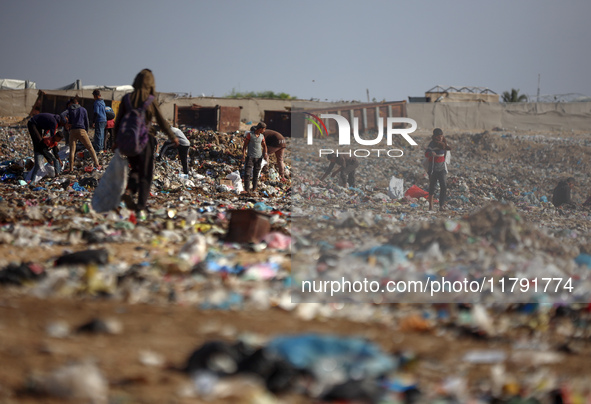 A Palestinian searches through a pile of garbage in Khan Yunis, Gaza Strip, on November 19, 2024, amid the ongoing war between Israel and th...