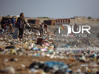 A Palestinian searches through a pile of garbage in Khan Yunis, Gaza Strip, on November 19, 2024, amid the ongoing war between Israel and th...