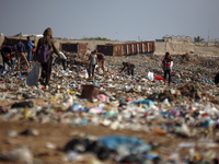 A Palestinian searches through a pile of garbage in Khan Yunis, Gaza Strip, on November 19, 2024, amid the ongoing war between Israel and th...