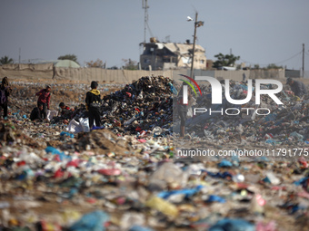 A Palestinian searches through a pile of garbage in Khan Yunis, Gaza Strip, on November 19, 2024, amid the ongoing war between Israel and th...