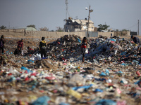 A Palestinian searches through a pile of garbage in Khan Yunis, Gaza Strip, on November 19, 2024, amid the ongoing war between Israel and th...