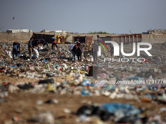 A Palestinian searches through a pile of garbage in Khan Yunis, Gaza Strip, on November 19, 2024, amid the ongoing war between Israel and th...