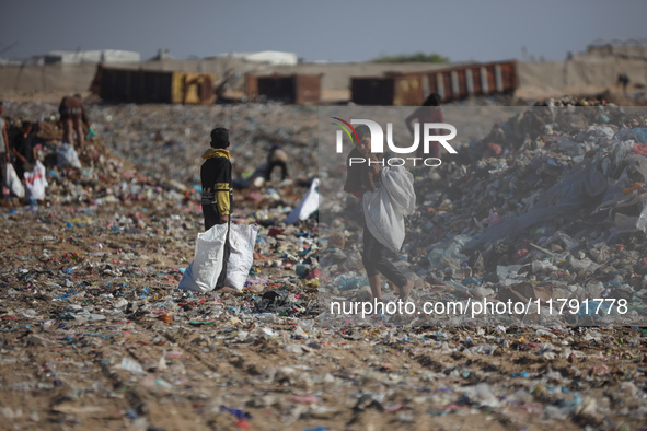 A Palestinian searches through a pile of garbage in Khan Yunis, Gaza Strip, on November 19, 2024, amid the ongoing war between Israel and th...