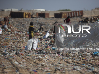 A Palestinian searches through a pile of garbage in Khan Yunis, Gaza Strip, on November 19, 2024, amid the ongoing war between Israel and th...