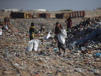 A Palestinian searches through a pile of garbage in Khan Yunis, Gaza Strip, on November 19, 2024, amid the ongoing war between Israel and th...