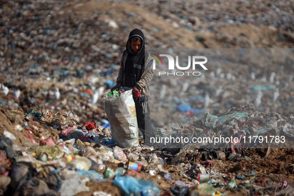 A displaced Palestinian boy searches through a pile of garbage in Khan Yunis, Gaza Strip, on November 19, 2024, amid the ongoing war between...