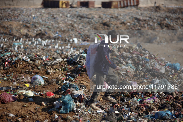 A displaced Palestinian boy searches through a pile of garbage in Khan Yunis, Gaza Strip, on November 19, 2024, amid the ongoing war between...