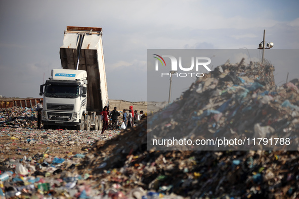 A Palestinian searches through a pile of garbage in Khan Yunis, Gaza Strip, on November 19, 2024, amid the ongoing war between Israel and th...