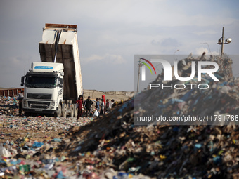 A Palestinian searches through a pile of garbage in Khan Yunis, Gaza Strip, on November 19, 2024, amid the ongoing war between Israel and th...