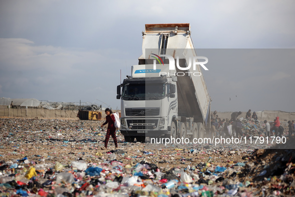 A Palestinian searches through a pile of garbage in Khan Yunis, Gaza Strip, on November 19, 2024, amid the ongoing war between Israel and th...