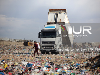 A Palestinian searches through a pile of garbage in Khan Yunis, Gaza Strip, on November 19, 2024, amid the ongoing war between Israel and th...