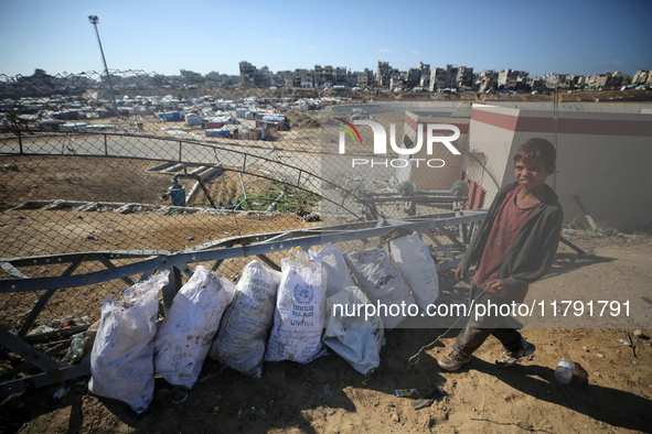 A displaced Palestinian boy searches through a pile of garbage in Khan Yunis, Gaza Strip, on November 19, 2024, amid the ongoing war between...