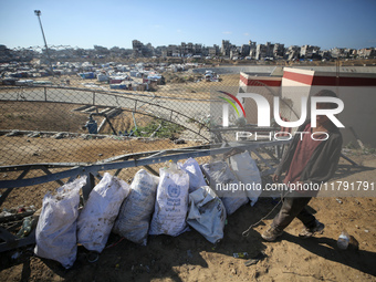 A displaced Palestinian boy searches through a pile of garbage in Khan Yunis, Gaza Strip, on November 19, 2024, amid the ongoing war between...