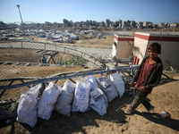 A displaced Palestinian boy searches through a pile of garbage in Khan Yunis, Gaza Strip, on November 19, 2024, amid the ongoing war between...