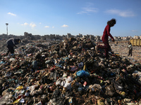 A Palestinian searches through a pile of garbage in Khan Yunis, Gaza Strip, on November 19, 2024, amid the ongoing war between Israel and th...