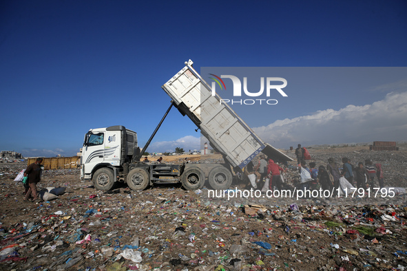 A Palestinian searches through a pile of garbage in Khan Yunis, Gaza Strip, on November 19, 2024, amid the ongoing war between Israel and th...