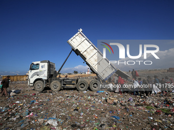 A Palestinian searches through a pile of garbage in Khan Yunis, Gaza Strip, on November 19, 2024, amid the ongoing war between Israel and th...