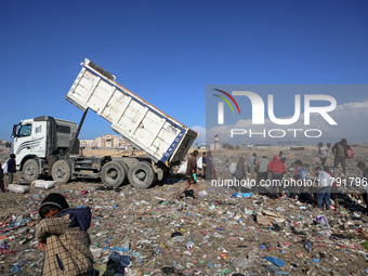 A Palestinian searches through a pile of garbage in Khan Yunis, Gaza Strip, on November 19, 2024, amid the ongoing war between Israel and th...