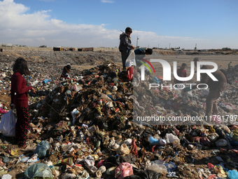 A Palestinian searches through a pile of garbage in Khan Yunis, Gaza Strip, on November 19, 2024, amid the ongoing war between Israel and th...