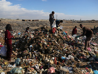 A Palestinian searches through a pile of garbage in Khan Yunis, Gaza Strip, on November 19, 2024, amid the ongoing war between Israel and th...