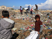 A Palestinian searches through a pile of garbage in Khan Yunis, Gaza Strip, on November 19, 2024, amid the ongoing war between Israel and th...